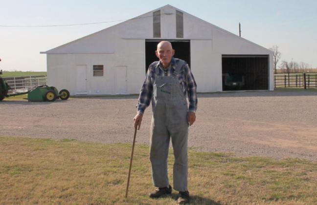 In spring 2021, Raymond Stover stands in front of the barn he built 70 years prior on his Yukon farm. He repurposed materials from a Stockyard City packing plant, in Oklahoma City, to make the structure. Photo / Carol Mowdy Bond