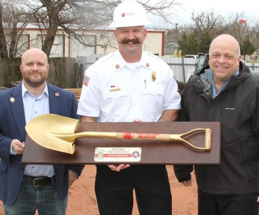 The City of Mustang hosted a groundbreaking for Fire Station No. 2 Tuesday. Pictured in the top photo from left, Mayor Brian Grider, Fire Chief Craig Carruth and City Manager Tim Rooney. In the photo to the right, Todd Martin helps his wife Shari with a hard hat. Photos / Michael Pineda