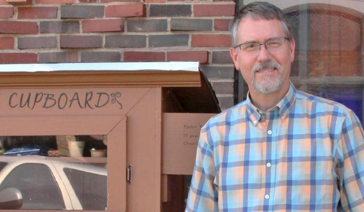 Rev. Dr. Kirt Moelling stands beside the First United Methodist Church’s new “Care Cupboard,” located outside on the southwest corner of 4th and Elm Streets, which is also the northeast corner of the church building. Photo / Carol Mowdy Bond