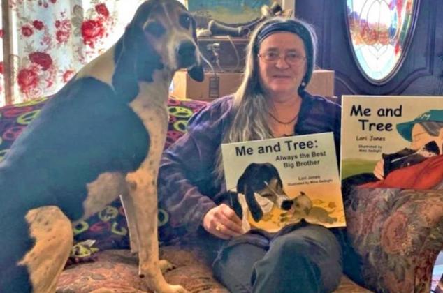A coonhound named Tree, on the left, helps Lori Jones showcase Jones’ two books at Haven of Hope Rescue in Canadian County. Photo / Provided